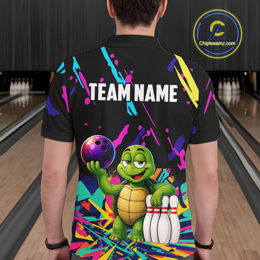 Person wearing a black bowling shirt with colorful design and turtle graphic in a bowling alley.
