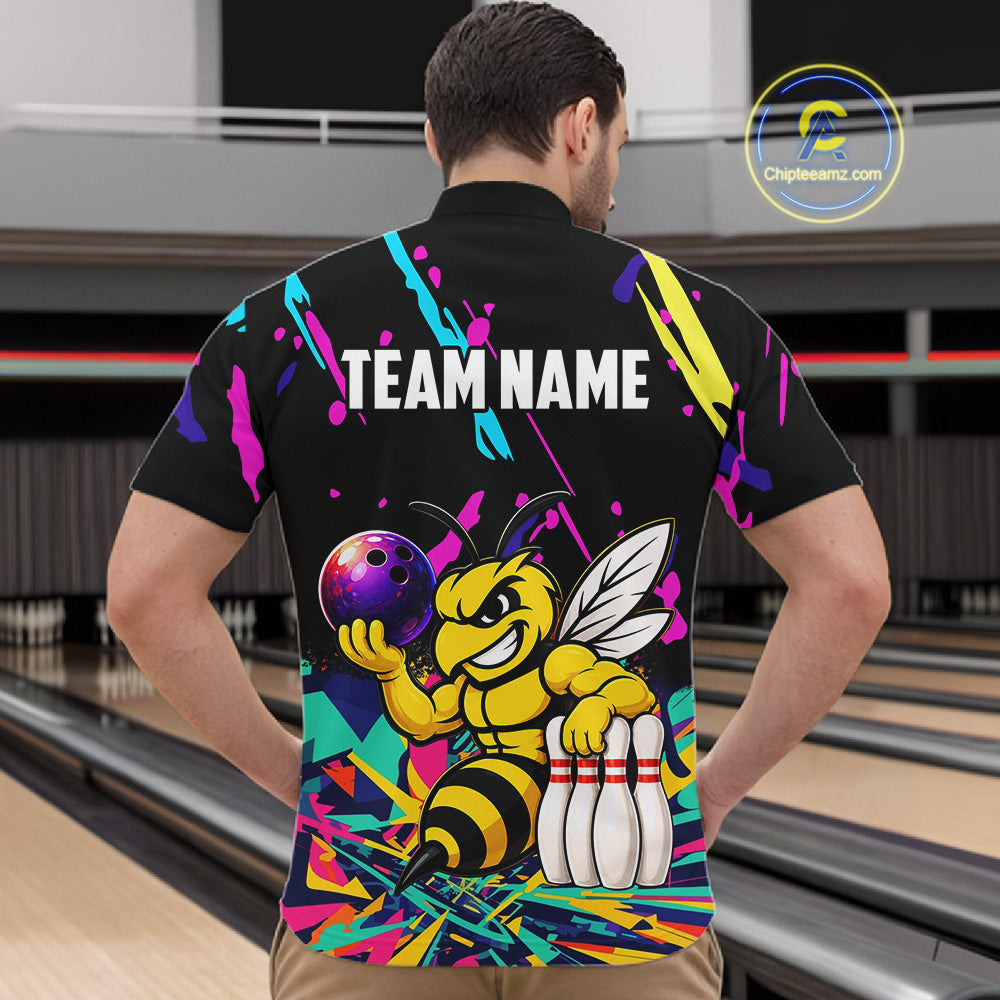 Person wearing a colorful bowling-themed shirt with a bee design in a bowling alley.