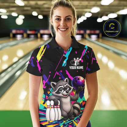 Woman wearing a colorful bowling-themed shirt with a raccoon graphic in a bowling alley.