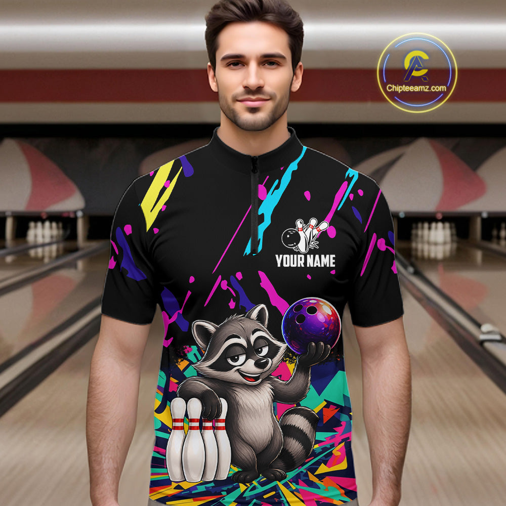 Man wearing a colorful bowling shirt with a raccoon graphic in a bowling alley.
