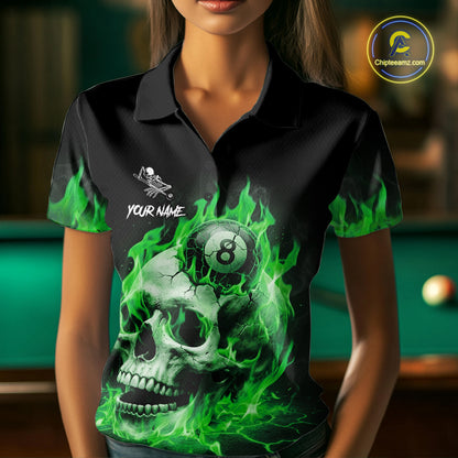 Woman wearing a green flaming skull 8 ball billiard jersey beside a pool table front view.
