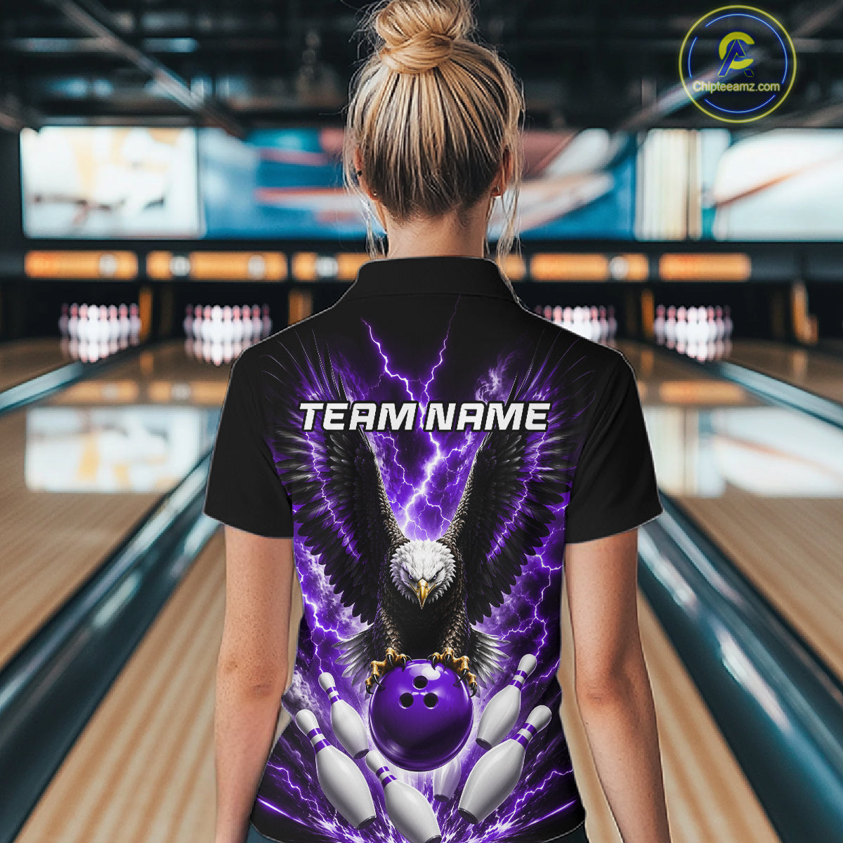 Back view of woman wearing a purple thunder lightning eagle bowling polo shirt inside a bowling alley.